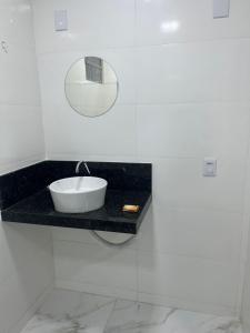 a bathroom with a sink and a mirror on a counter at Casa do Alessandro in Vila Velha
