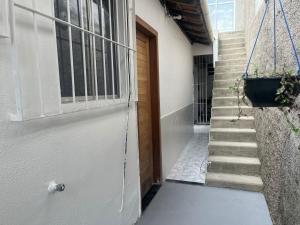 a door to a building with a staircase next to it at Casa do Alessandro in Vila Velha +2 photos