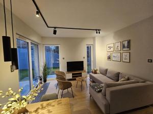 uma sala de estar com um sofá e uma TV em Apartament Na Urlop - Wisła - Magiczny Horyzont em Wisła