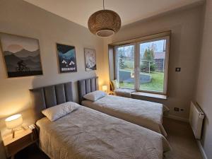 um quarto com duas camas e uma janela em Apartament Na Urlop - Wisła - Magiczny Horyzont em Wisła