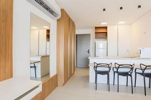 a kitchen with a table and chairs and a counter at Stay Pure | Design Clean e Atmosfera Tranquila in Campo Grande