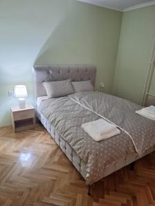 a bedroom with a bed and a wooden floor at Rustic Elegance Suite in Vrbas