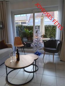 ein Wohnzimmer mit einem Tisch und zwei Stühlen in der Unterkunft T3 rez-de-chaussée lumineux avec terrasse proche plage in Cucq