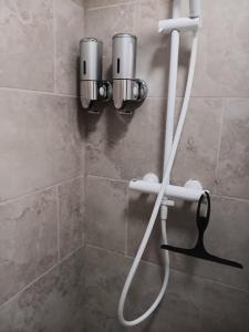 eine Dusche mit einem an der Wand befestigten Schlauch in der Unterkunft T3 rez-de-chaussée lumineux avec terrasse proche plage in Cucq