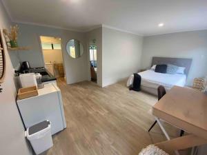 ein Schlafzimmer mit einem Bett, einem Schreibtisch und einem Tisch in der Unterkunft The Sugar shack in Tauranga