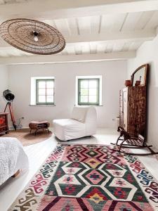 a living room with a white couch and a rug at Makravölgyi Házikó in Csajág