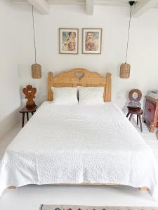 a bedroom with a bed with a white bedspread at Makravölgyi Házikó in Csajág +20 photos