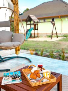 a tray of pastries on a table next to a playground at Makravölgyi Házikó in Csajág