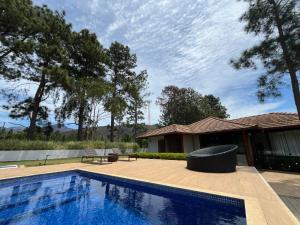 a swimming pool in front of a house at Casa 09 Monte Boa Vista - Refúgio com Piscina Privativa, Sauna e Vista das Montanhas in Teresópolis