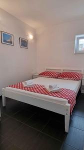 twee bedden in een kamer met rode en witte lakens bij Apartment Mimice 4 in Mimice