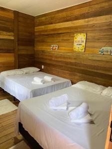 duas camas em um quarto com paredes de madeira em Morada do Amor em Belém
