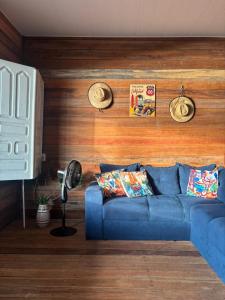 um sofá azul num quarto com uma parede de madeira em Morada do Amor em Belém