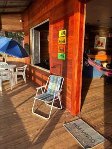 uma cadeira de baloiço sentada no alpendre de uma cabina em Morada do Amor em Belém