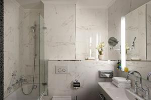 a white bathroom with a shower and a sink at Grand Hotel Suisse Majestic, Autograph Collection in Montreux +52 photos