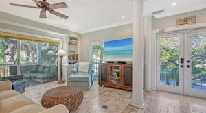 a living room with a couch and chairs and windows at Hemingway House - 117 in Siesta Key