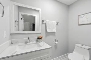 a white bathroom with a sink and a toilet at Brand new custom 4BR house in Oshawa