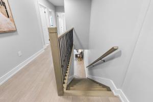 a stairway with a wooden rail and a stair case at Brand new custom 4BR house in Oshawa +7 photos