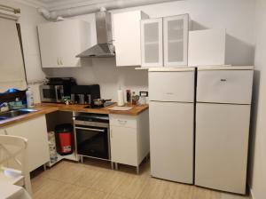 a kitchen with white cabinets and a white refrigerator at casa cairasco in Las Lagunas