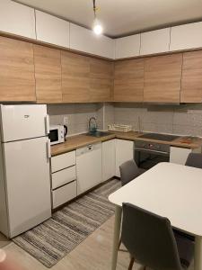 a kitchen with a white refrigerator and a table at Flat in Fushë Kosova in Kosovo Polje