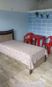 ein Schlafzimmer mit einem Bett und einem Tisch und Stühlen in der Unterkunft Pousada Nan in Salvador