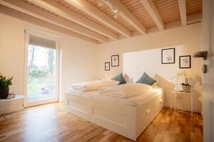 诺德霍恩Dock 2 - tolles Ferienhaus für bis zu 6 Personen mit Kaminofen und Sauna - Haustiere herzlich willkommen的一间白色卧室,房间内设有两张床