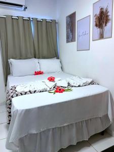 um quarto com uma cama com flores vermelhas em Pousada do Trinta em Fernando de Noronha