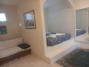 a small bedroom with a bed and a mirror at Κτήμα Ανάσες Ζωής- Ευγενία Σγούρα in Epanomi