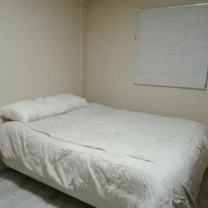 Una cama blanca en una habitación blanca con una foto en la pared en Cabaña en Valdivia, Chile, en Valdivia