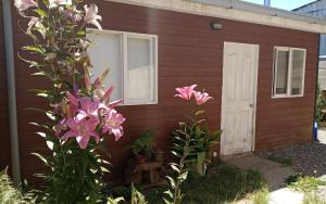 una casa roja con flores rosas delante en Cabaña en Valdivia, Chile, en Valdivia