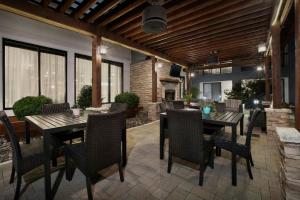 Courtyard by Marriott Dallas DFW Airport North/Irving في ايرفينغ: فناء به طاولات وكراسي ومدفأة