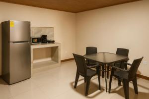 a dining room with a table and a refrigerator at Fraijanes Mountain Stay in Alajuela +13 photos