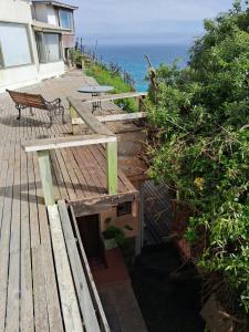 a wooden deck with a bench and the ocean at Vistas espectaculares in Mirasol +5 photos
