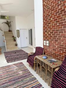 a living room with two chairs and a brick wall at Karima house B in Al Aqālitah