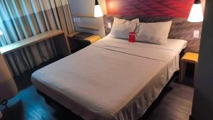 タトゥイーにあるibis Tatuiのホテルの部屋のベッドの上に赤いカップが置かれている