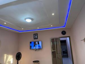 a room with a tv on a ceiling with blue lights at Résidence saint-Gall-H in Ouidah