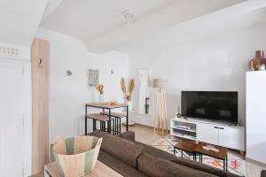 a living room with a couch and a tv at Oustau de Gemo - Maison confort au cœur de Gémenos in Gémenos