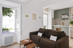 a living room with a couch and a table at Oustau de Gemo - Maison confort au cœur de Gémenos in Gémenos