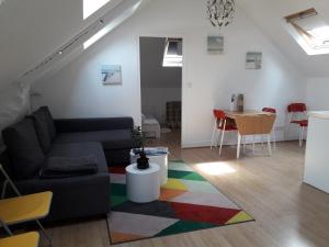 a living room with a couch and a table at Un nid cosy sous les toits in Cancale +13 photos