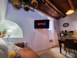 a living room with a netflix sign on the wall at Casa Bella in Central Noto, a Unique Sicilian Stay in Noto