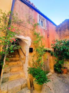 an old building with stairs and plants in front of it at Casa Bella in Central Noto, a Unique Sicilian Stay in Noto
