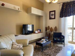 a living room with a couch and a flat screen tv at Birgu SeaView Apartment in Birgu