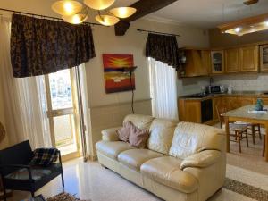 a living room with a couch and a kitchen at Birgu SeaView Apartment in Birgu