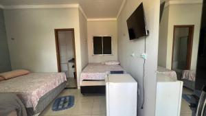 una piccola stanza con due letti e una televisione di Chalés do Atlântico a Salinópolis