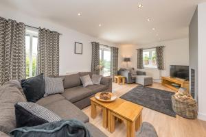 a living room with a couch and a table at Adwyr-Mynydd in Dinorwic