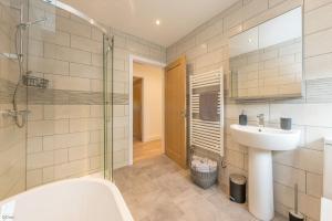 a bathroom with a sink and a tub and a shower at Adwyr-Mynydd in Dinorwic +24 photos