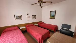 Una habitación con dos camas y un ventilador de techo. en Hotel Internacional Necochea, en Necochea