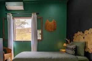 a green bedroom with a bed and a window at Casa Archipel - Lagedos in Ribeira Fria +34 photos