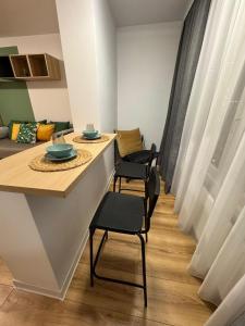 una habitación con una mesa y sillas y un sofá en Studio Lumiere Timișoara, en Timisoara