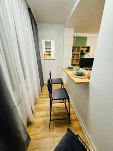 Habitación con 2 sillas y escritorio. en Studio Lumiere Timișoara, en Timisoara