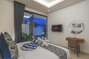 a bedroom with a bed and a desk and a window at Villa Kusuma 3 Seminyak in Badung +50 photos